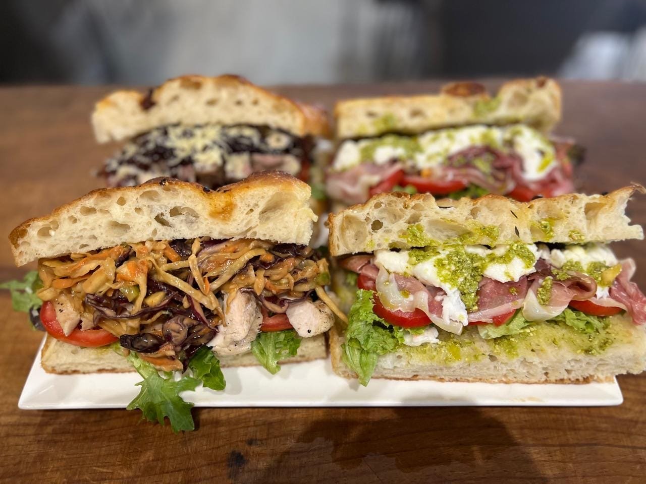 Two focaccia sandwiches — chicken slaw, and prosciutto with mozzarella and pesto